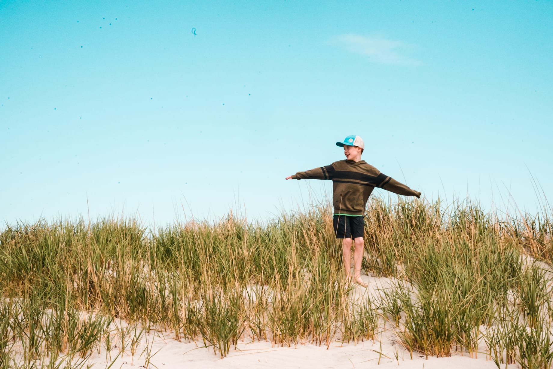 Kerri's son playing in the beach grass on the dunes in Nova Scotia
